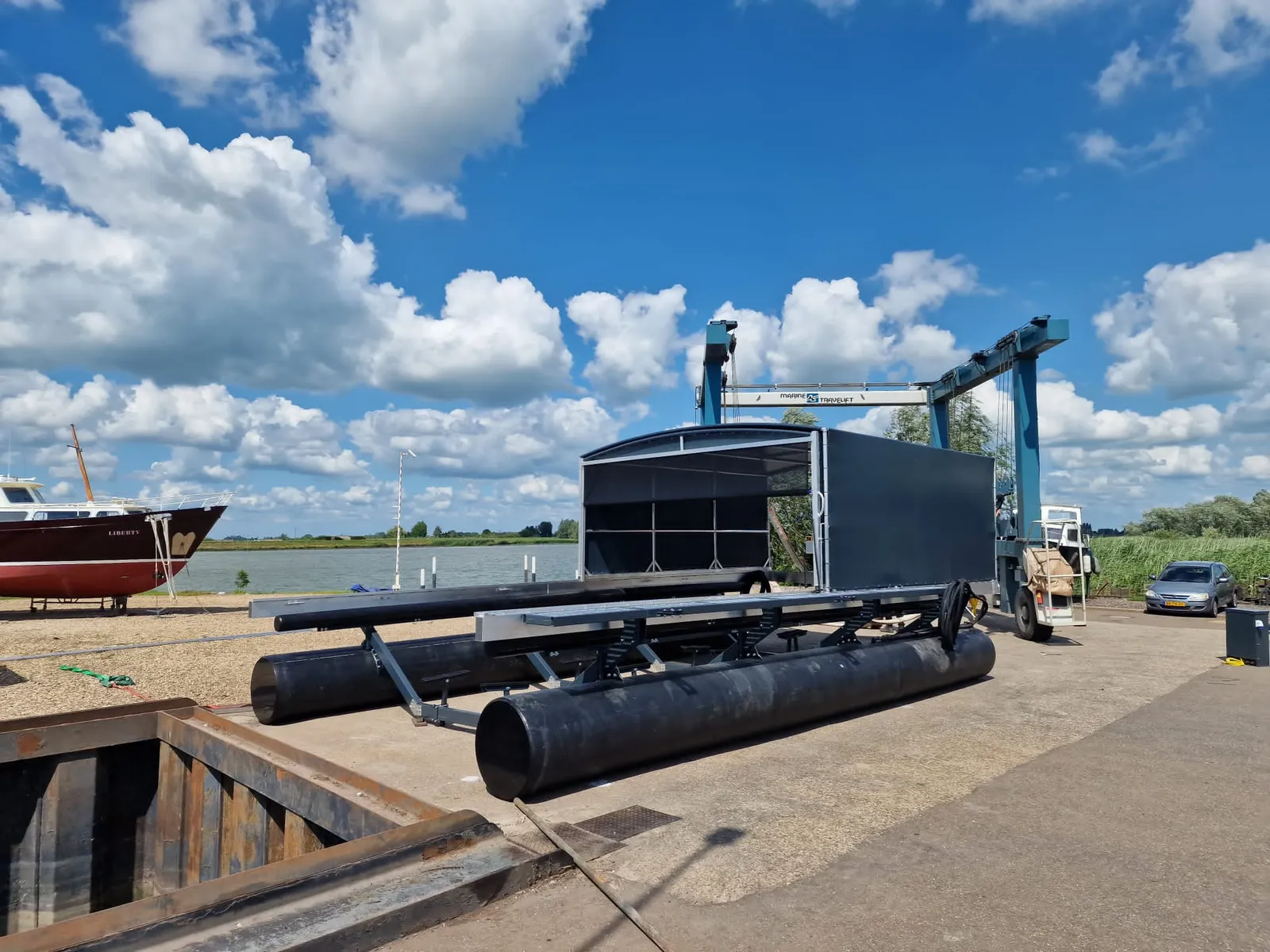 Boothuis met bootlift op de kade van de werf
