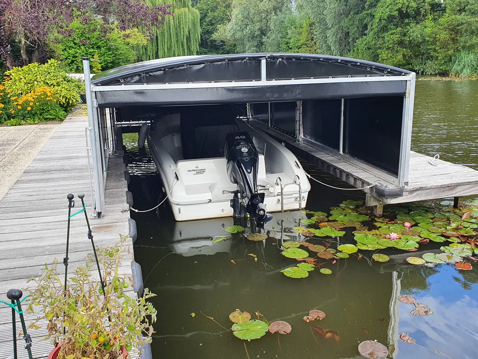 Motorboot onder een geopende bootoverkapping tussen waterlelies